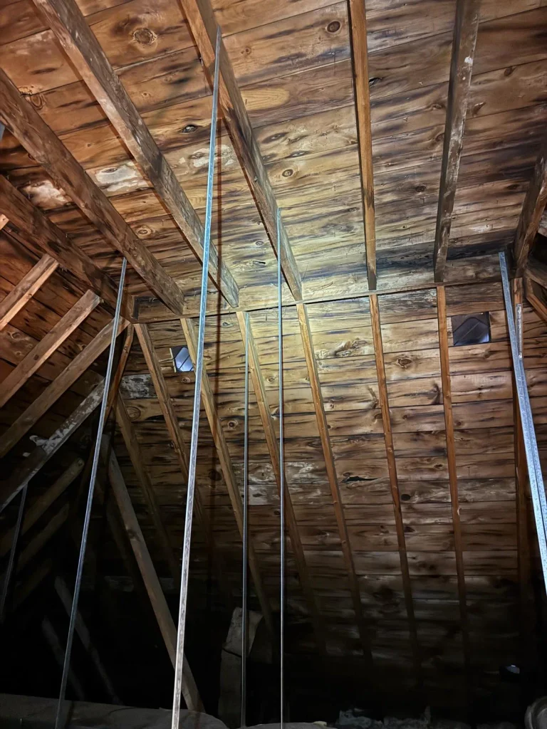 Existing Burlington attic with wood rafters and temporary steel supports