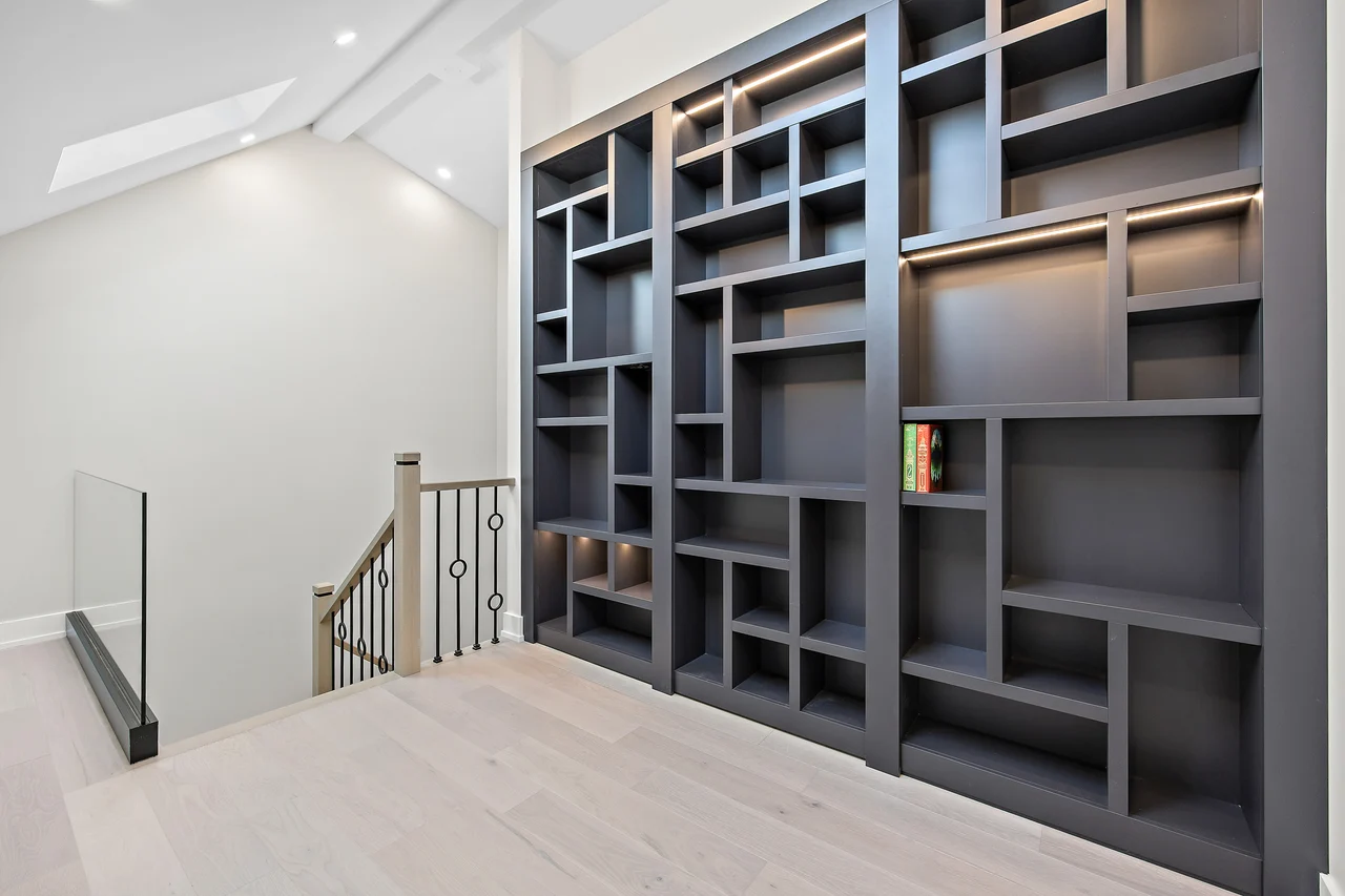 Finished attic landing with dark built-in shelving beside the stairs
