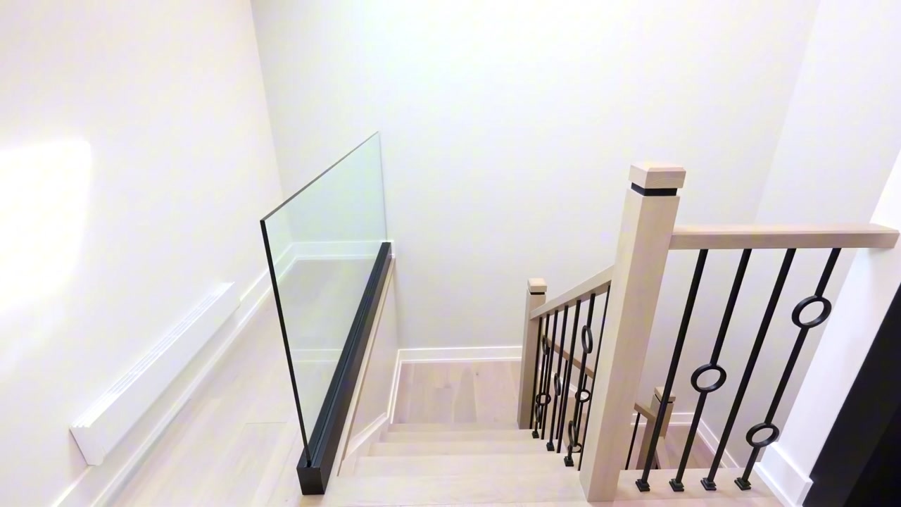 Finished interior staircase with glass guard and black metal balusters